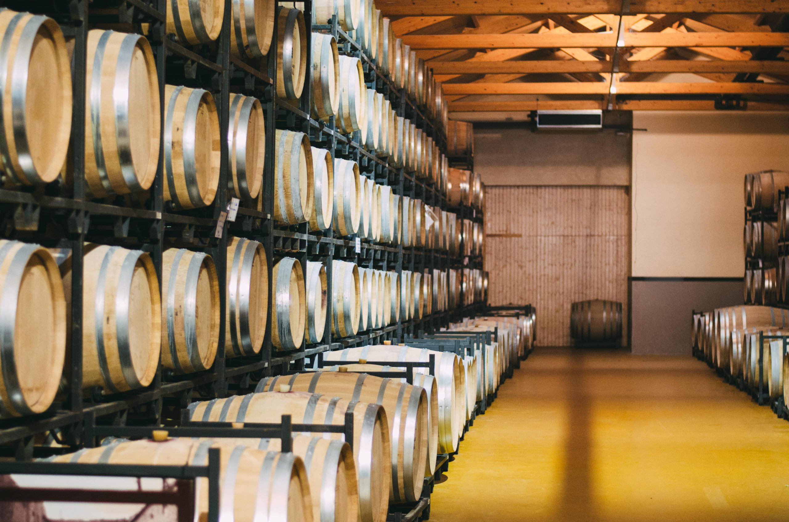 imagem de uma sala com vários barris de vinhos empilhados