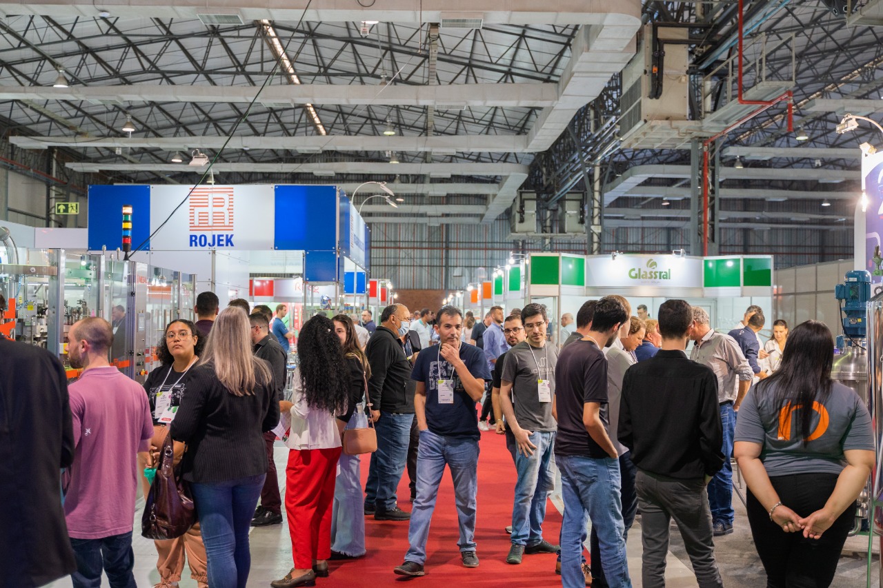 Ambiente de feira industrial com empresas de envase, fornecedores e equipamentos conectando negócios no setor